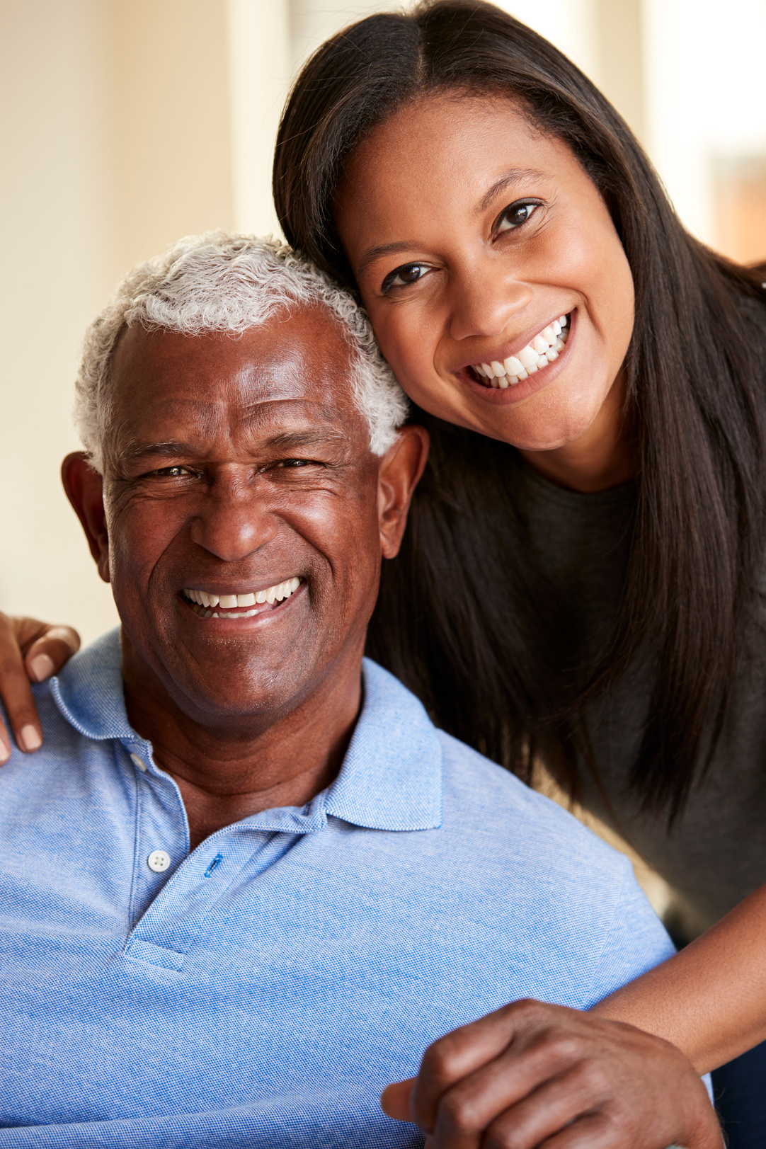 Portrait of Smiling Senior Father Being Hugged by Adult Daughter